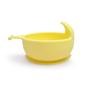 Dettaglio ciotola con ventosa in silicone per neonati, piatto giallo antiscivolo per bambini.