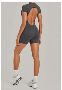 Detail view of the dark grey open-back yoga jumpsuit, showing back cutout and tight fit.