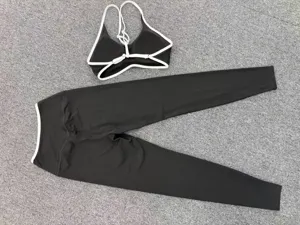 Details of black and white contrast trimmed yoga set featuring strappy sports bra and pants.