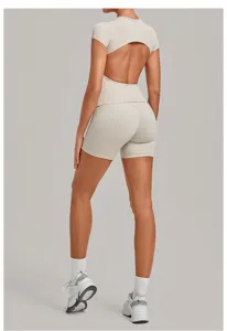 Back view of a beige backless short-sleeve yoga top and tight pleated shorts fitness two-piece set.
