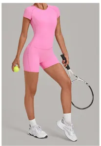 Détail de combinaison de sport rose, barboteuse à manches courtes avec short fitness et tennis.