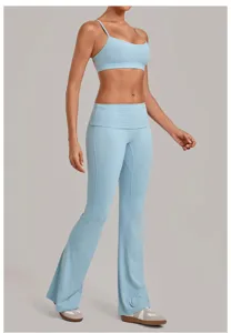 Lichtblauwe yogaset detail met halter crop top en uitlopende broek met omslagtaille.