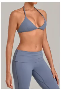 Κοντινή λήψη λεπτομέρειας σουτιέν γιόγκα halter, αθλητικό τοπ και κολάν γυμναστικής.