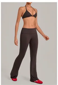 Detailed shot of women's halter yoga bra and flared pants set, sleek workout wear.