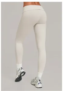 Achterkant van dames hoge taille kruising yoga legging in beige, elastische fitness sportbroek.