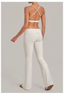 Rugdetail witte yogaset, sport-bh met kruisbandjes en uitlopende broek met hoge taille.