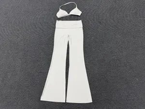 White yoga set detail, flat lay view showing fold-over waist flare pants and camisole bra.