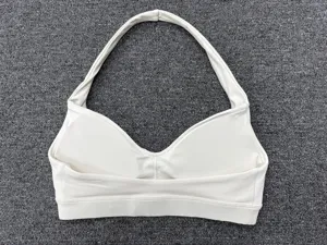 Close-up view of a white halter deep V yoga bra, showing fitness athletic design