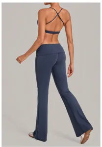 Achterkant detail van blauwe sport-bh met kruisbandjes en uitlopende yogabroek.