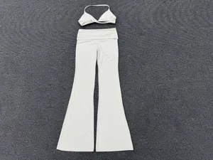 White two-piece yoga set featuring a strappy bralette and fold-over waist flare pants.