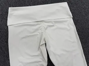 Beige yogabroek met omslagtaille en gerimpelde achterkant voor fitness en sport.