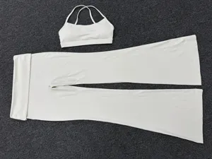 Witte yogaset detail met sport-bh met kruisrug en uitlopende yogabroek met omgeslagen taille.