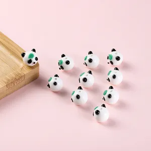 Primo piano dettagliato di simpatiche perle di vetro panda per collana gioielli fai da te.