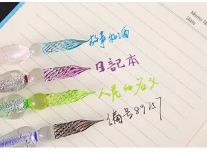 Vue détaillée de plumes en verre colorées avec des pointes de cristal en spirale et de l'encre.
