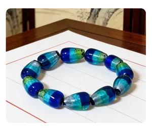 Close-up detail of the colorful gradient silver foil teardrop glass bead bracelet jewelry.