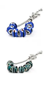 Detailansicht eines silbernen Schlangenkettenarmbands mit blau-grünen Muranoglasperlen.