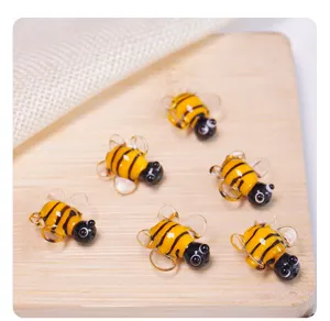 Detailed close-up view of cute glass bee beads, perfect for DIY jewelry making and crafting.