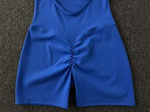 Vue détaillée du short combi de yoga fitness bleu, avec col rond et fronces à l'arrière.