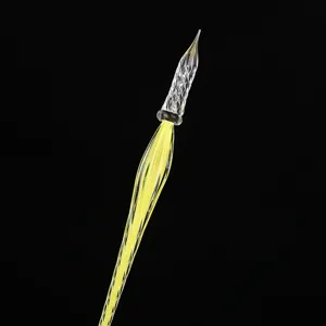 Plume de verre artisanale avec pointe spirale transparente et manche rayé jaune.