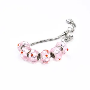 Bracelet jonc en argent avec perles de verre roses à fleurs et points orange bijoux.