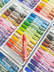 Hexagonal oil pastels set for student art drawing, colorful crayons in tray, vibrant painting tools.