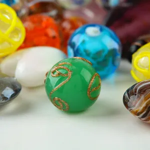 Colorful DIY glass beads mix with gold glitter swirl patterns, vibrant decorative craft supplies.