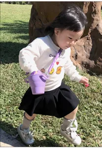 Portable collapsible silicone baby snack cup with double ears and strap for toddlers.