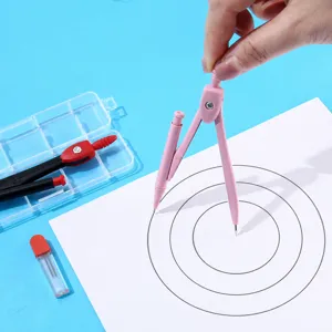 Primer plano de compás de metal rosa dibujando círculos precisos en papel con caja de almacenamiento.