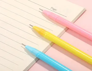 Primer plano de bolígrafos de gel coloridos en rosa, amarillo y azul sobre cuaderno.