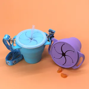 Portable silicone baby snack cup with straw, strap and collapsible design for toddlers.