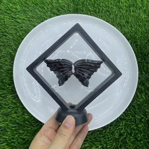 Close-up detail of natural gemstone butterfly wings in a black floating display frame stand.