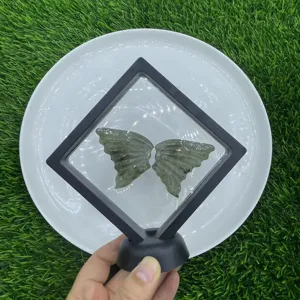 Close-up view of carved natural gemstone butterfly wings in a floating black display frame.