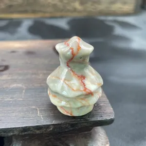 Close up view of a small natural stone Christmas tree carving, delicate crystal decor.