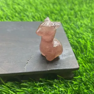 Detailopname van het schattige kristallen alpaca beeldje op een houten sokkel met fijne textuur.