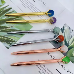 Metal ballpoint pens featuring natural stone crystal spheres in claw settings, assorted colors.