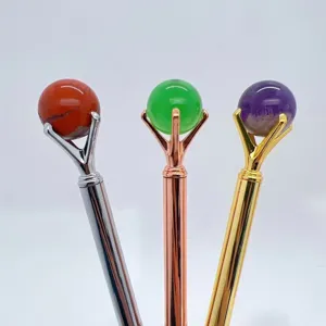 Crystal ball pen detail showing natural stone sphere and metal prong wand holder design.