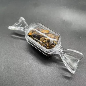 Nahaufnahme der klaren Glasbonbonflasche gefuellt mit natuerlichen Tigerauge Steinen als Dekoration.