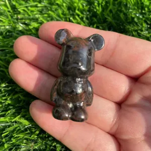 Primo piano di una statuetta di orso in pietra naturale, dettaglio scultura liscia.