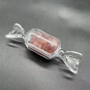 Detailansicht des niedlichen bonbonformigen Behaelters gefuellt mit rosa Kristallkies.