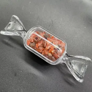 Nahaufnahme der bonbonförmigen Glasflasche mit roten Kristallsplittern als Dekoration.
