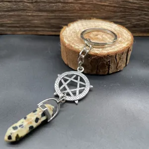 Detailaufnahme eines Edelstein Hexagon Säule Schlüsselanhänger mit Metall Pentagramm.