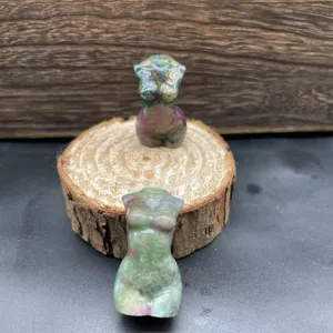 Gros plan de la sculpture de torse feminin en cristal naturel, mini figurine en pierre.