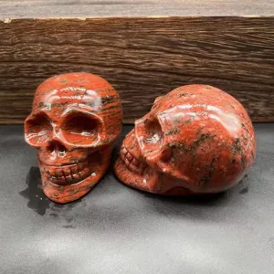Detailed view of natural red stone carved skull figurine, crystal gemstone decor sculpture.