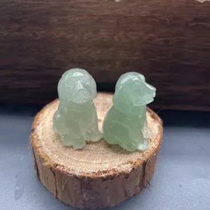 Nahaufnahme von zwei niedlichen geschnitzten Edelstein-Hundefiguren auf Holzscheibe.