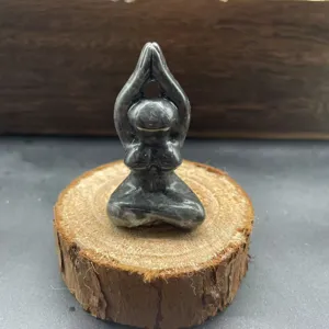 Detail shot of a natural stone carved yoga woman figurine, showcasing delicate texture and craft.