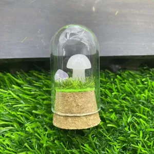 Vue détaillée de terrarium en verre champignon cristal avec sculpture en pierre et paysage miniature.