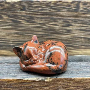 Statuette de chat endormi en cristal sculptée à la main, détail gros plan de décoration.