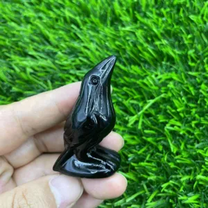Detail view of hand carved black crystal raven gemstone sculpture showing smooth polished texture.