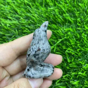 Close-up detail of hand-carved crystal raven bird figurine, natural gemstone mineral texture.