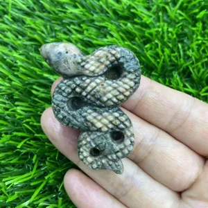 Gros plan détaillé d'une figurine de serpent en cristal sculpté en pierre naturelle de 5 cm.